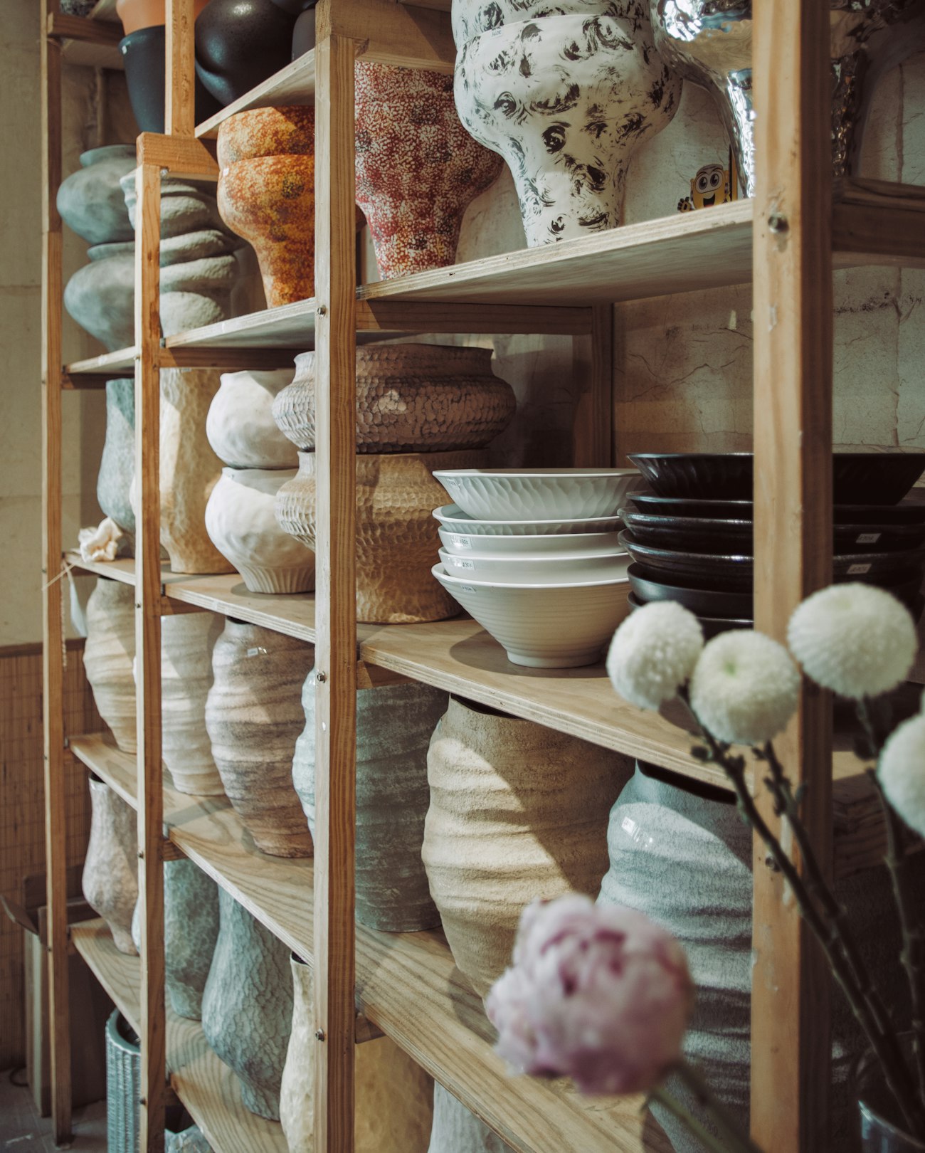 The shop shelves, stacked with ceramics and glassware